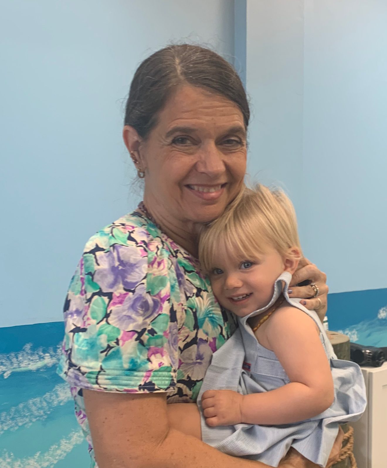 Dr. Karolyn holding a smiling toddler in the office