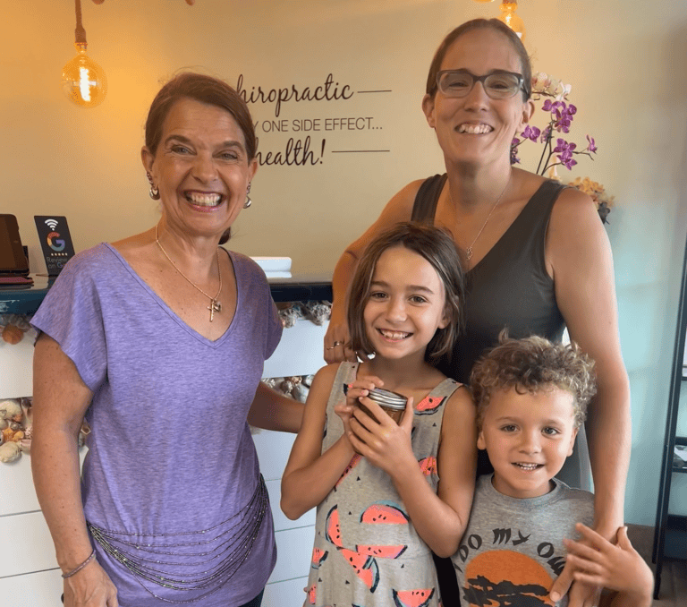 Dr. Karolyn posing with a mother and two children in the office