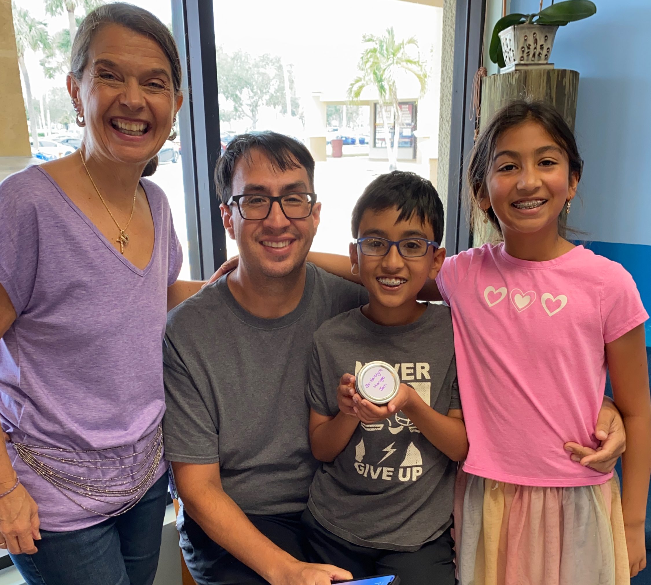 Dr. Karolyn posing with a father and two children in the office