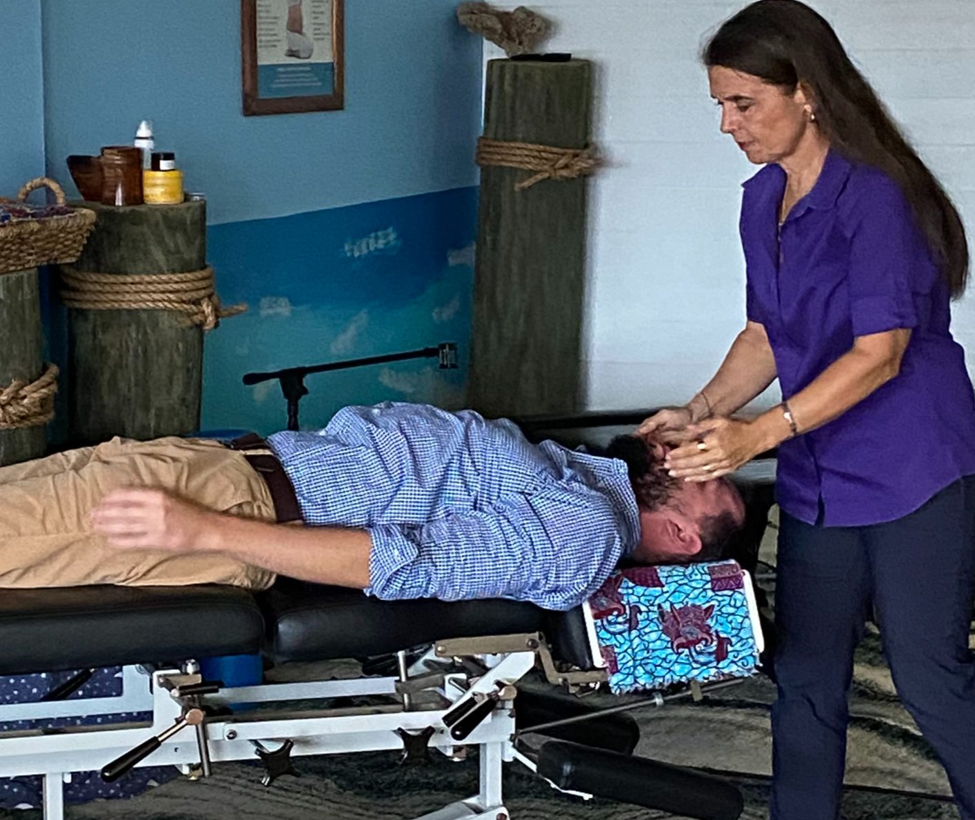 Dr. Karolyn performing a neck adjustment on a man lying on a table