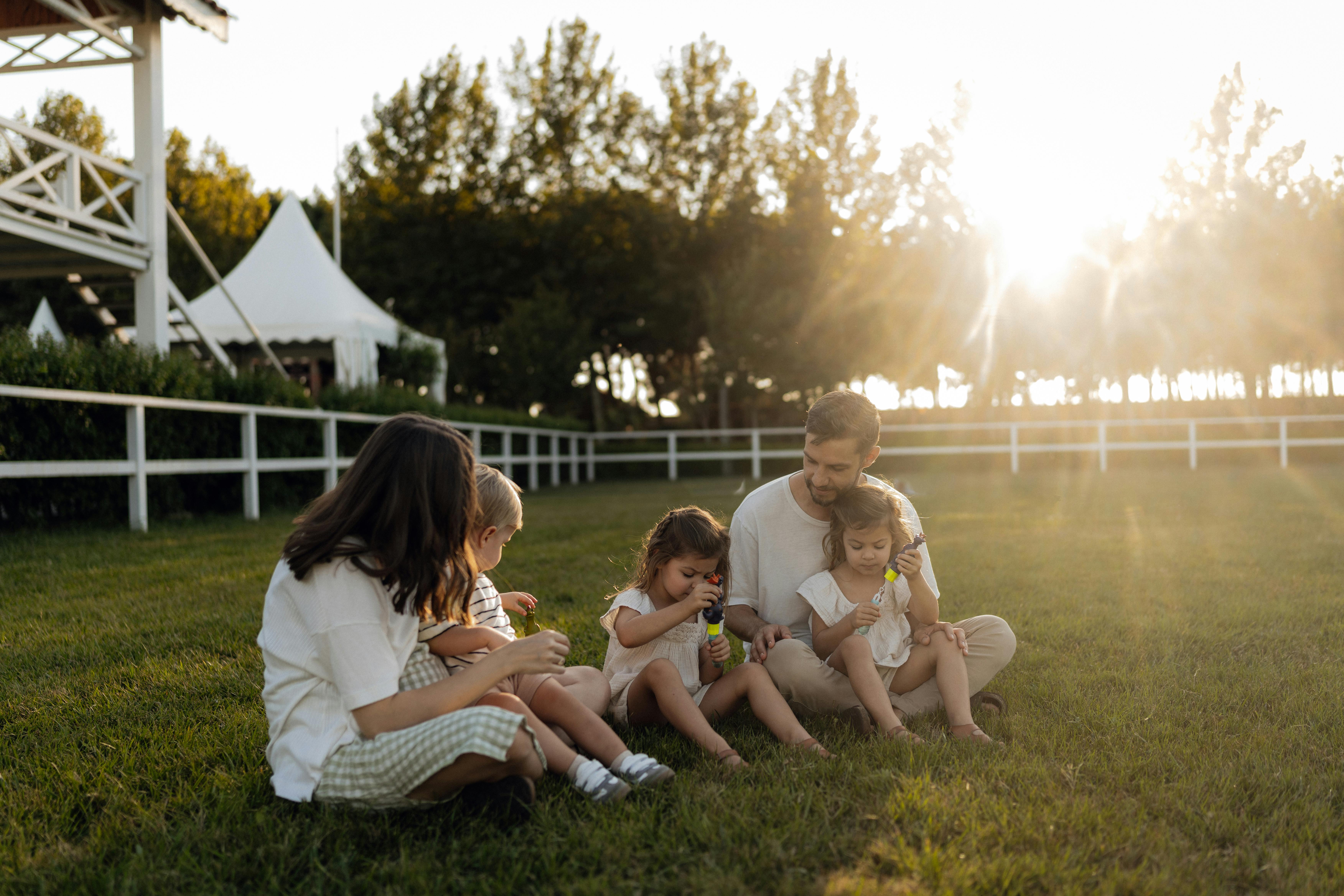 Family sitting together outdoors in a sunlit park