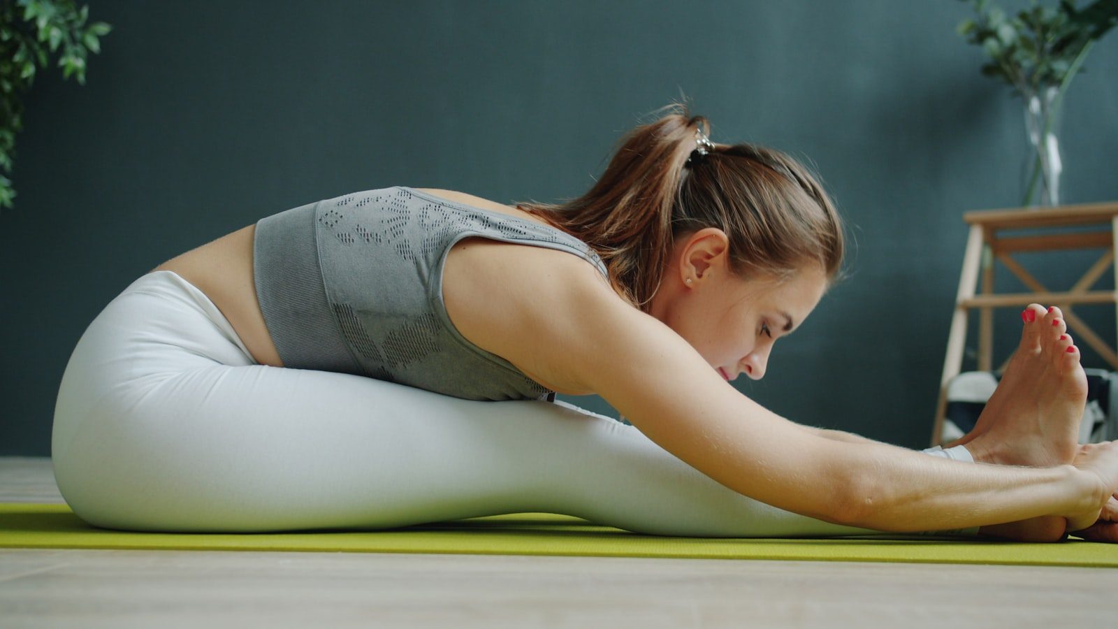 Woman stretching on a yoga mat indoors