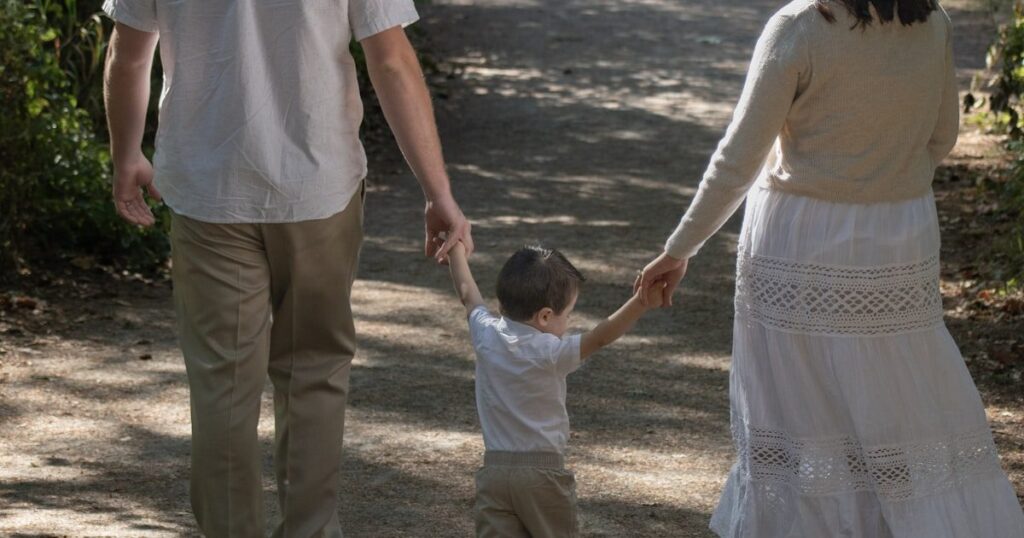 Family walking together on a wooded path