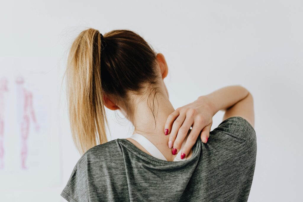 Woman touching back of shoulder